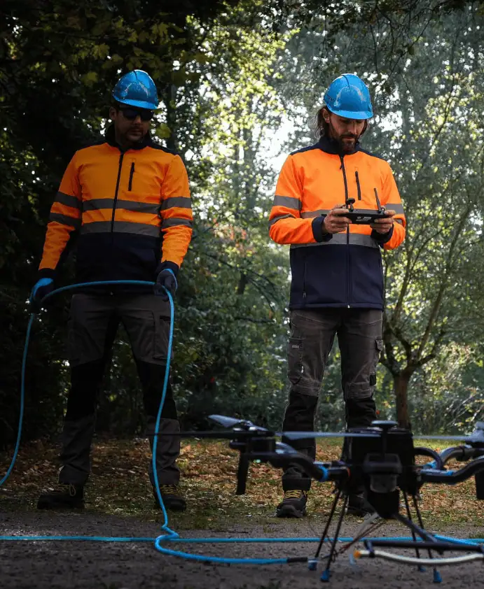Deux télépilotes Dronelis préparant le drone Cormoran avant une mission de démoussage